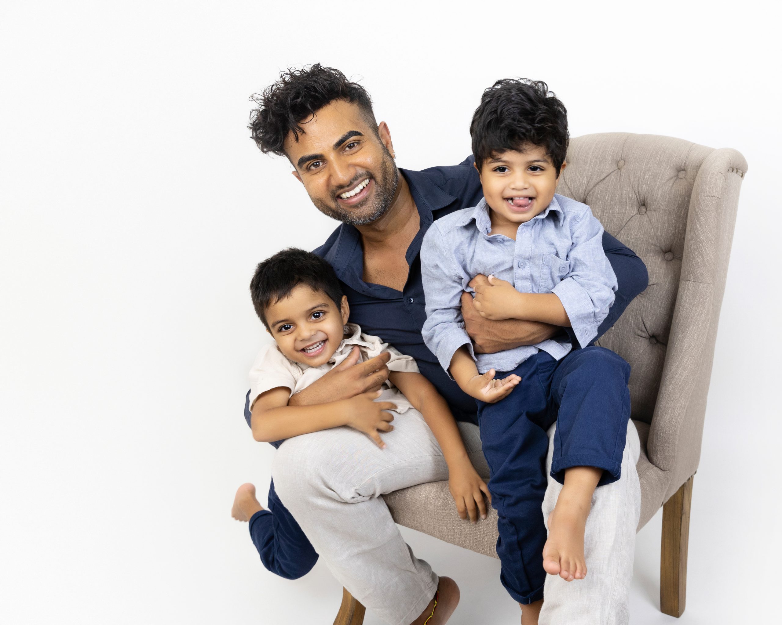 dad holding two sons in blue