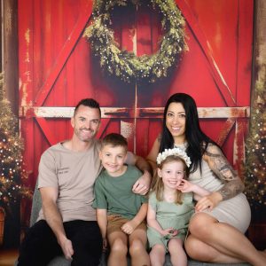family Christmas photo with Christmas wreath and Christmas trees
