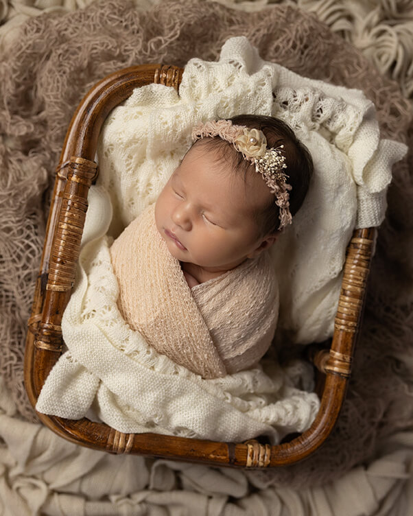 Newborn baby girl wrapped in beige during her photoshoot at Kristy’s Studio, Wentworth Falls