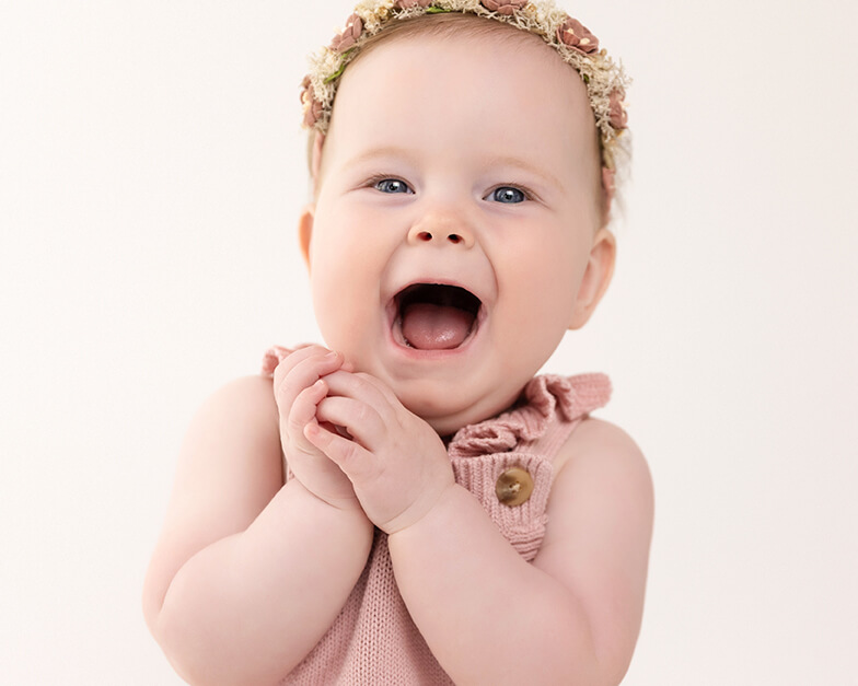 Sitter baby in pink laughing - studio photography