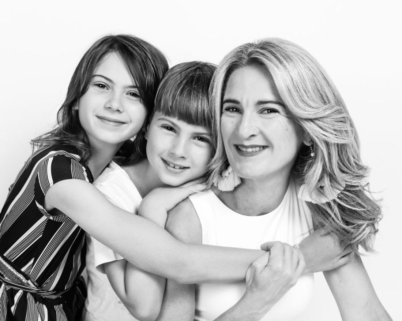 Family Photography at Kristy's Studio kids hugging mum and smiling black and white photography